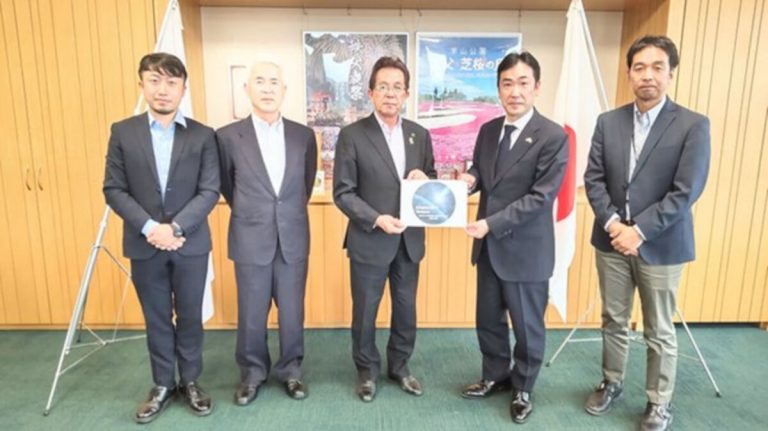 Kuvassa keskellä Chichibun pormestari Atsushi Kitahori. Kylttiä pitää Akira Yonetake (edustajamme). Kuva: Heikki Mäkipää