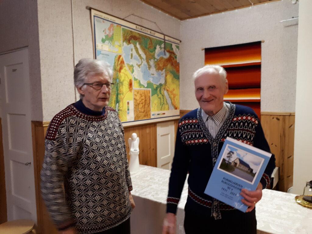 Lasse Hokkala luovuttaa juhlakirjan Veikko Hakalalle.