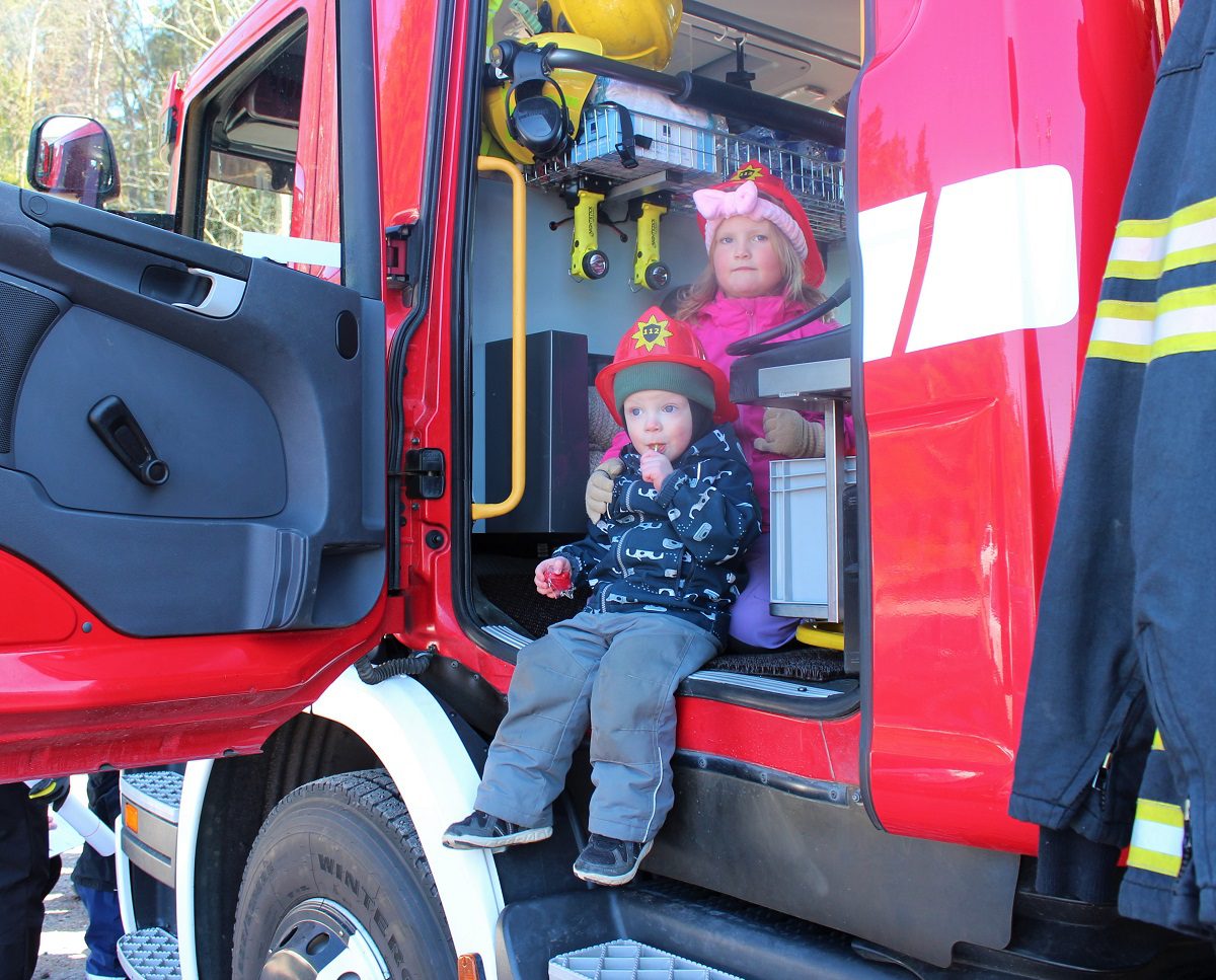 Elli ja Eino pääsivät istumaan paloautoon asianmukaiset kypärät päässään.