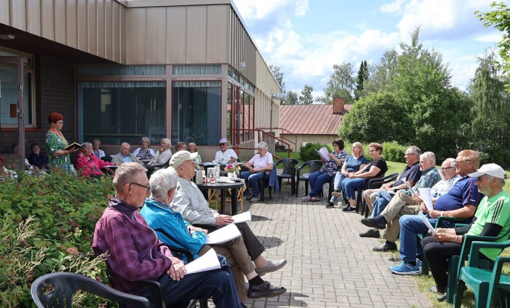 Elsa Rajala esittää runon Torilla tavataan-hetken osallistujajoukolle.