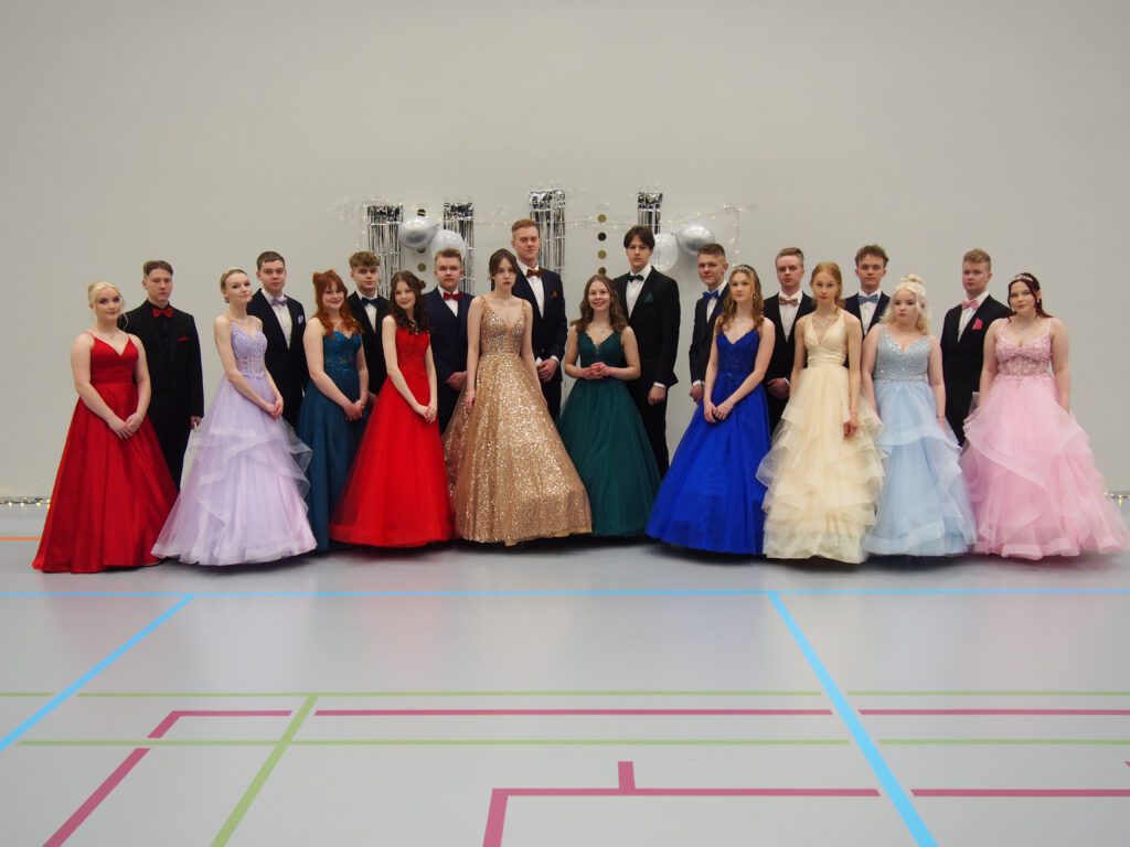 Lukion toisen vuosikurssin opiskelijat eli wanhat kauniissa asuissaan kokoontuivat yhteiskuvaan näyttävien tanssiesitysten välillä. Kuva: Mauri Lehto.