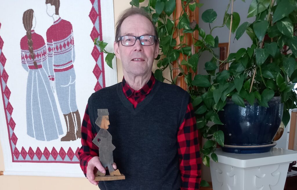 Leo Lamminen on kirjoittanut lapsuusmuistojaan jälkipolville muistikirjaansa. Kädessään hänellä on koulussa 50-luvun lopulla tekemänsä veistos