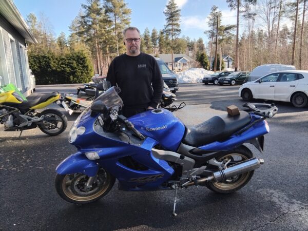 Marko Vainionpää ja sininen Kawasaki-katupyörä.