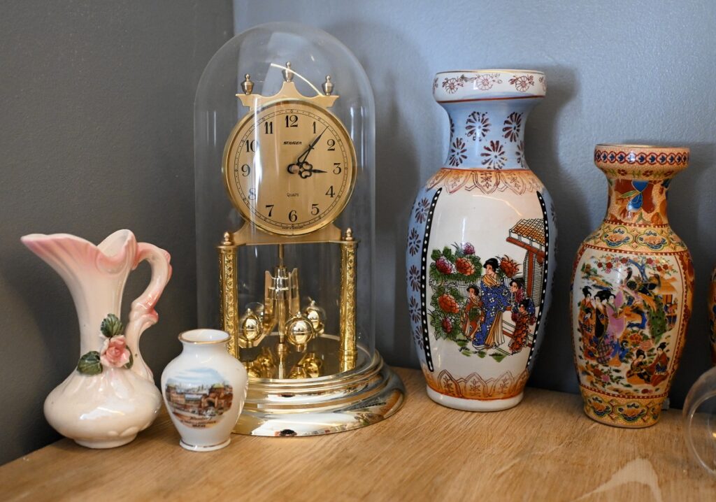 Elmerin huoneessa on vanha pöytäkalusto, ehkä 50-luvulta. Sen päälle on koottu kirpputorilta löytyneitä aarteita. –Tuommoista kelloa halusin pitkään ja vihdoin sellainen löytyi Adeliinasta edullisesti.