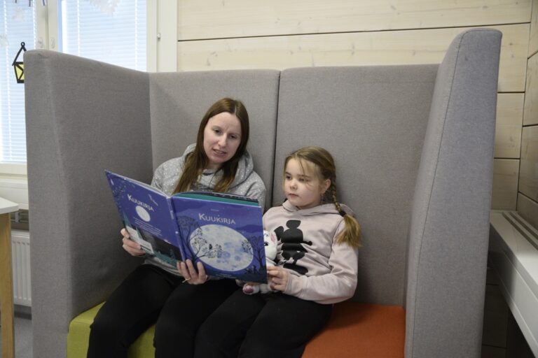 Esiopetuksen opettaja Marika Lammi lukee Ainolle. Lukutuokioissa myös lapsi voi lukea vapaaehtoiselle lukumummille tai -vaarille.