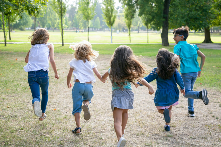 Group of kids running on grass together