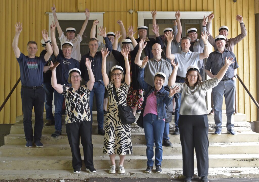 40 vuotta sitten ylioppilaaksi kirjoittaneet tuulettivat vanhan keskikoulun portailla. Alkuperäisessä kuvassa oli huomattavasti vakavampia nuoria.