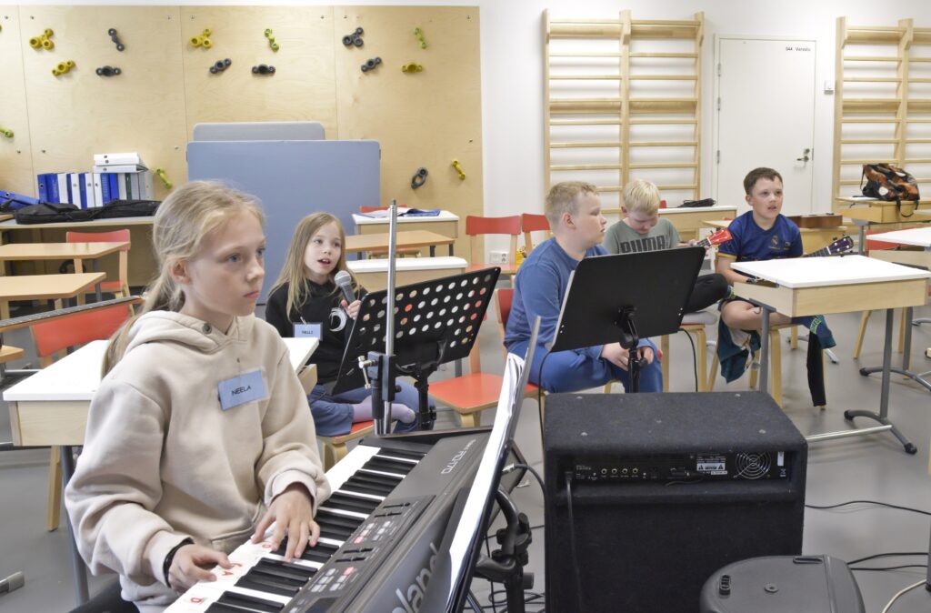 Neela, Nelli, Noel, Eemeli ja Timon soittavat Apinaorkesteri-kappaletta. 