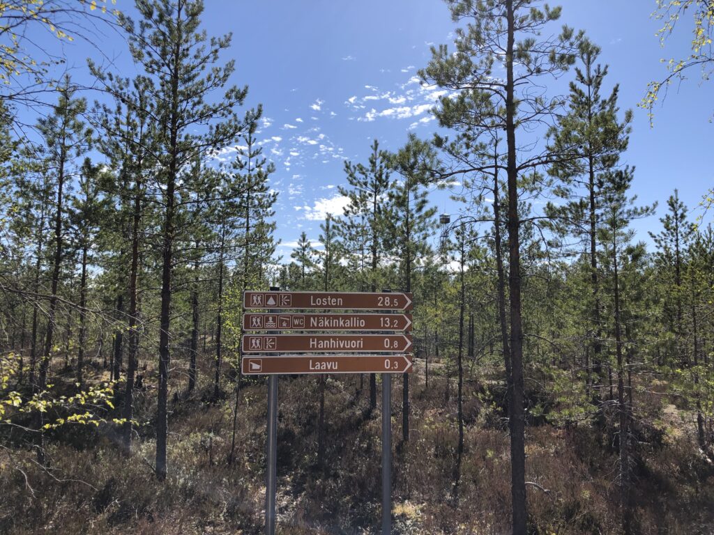 Kuva 1 parkkipaikan kyltti, taustalla näkötorni