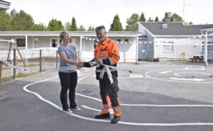 Päiväkodin johtaja Seija Aho ja talonmies Keijo Savola leikkasivat lasten koristeleman puuhapuiston avausnauhan.