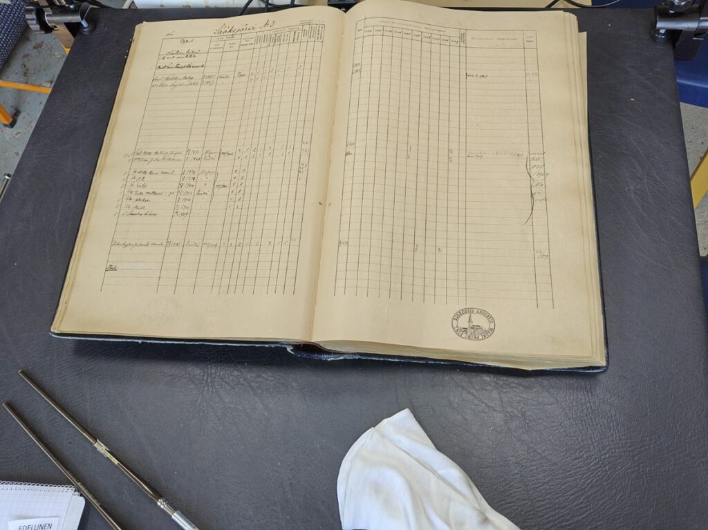 Kirkonkirjoja käsitellään puuvillakäsineet kädessä.