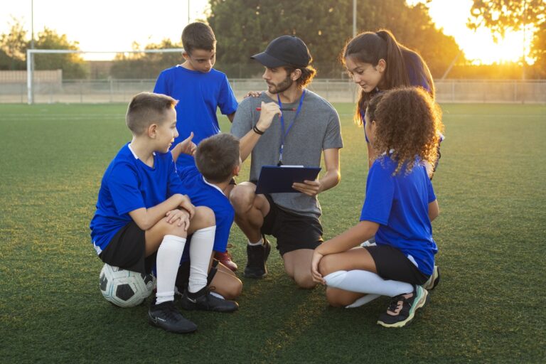 Football trainer teaching children front view
