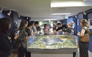 Meteoriittikeskuksen näyttelyssä Öhman ja Hyttinen näyttävät vierailijoille, missä olemme.