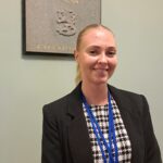 Emma-Lotta Annola Valtioneuvoston linnan tunnetuimmassa portaikossa. Taustalla on laatta vuonna 1904 tapahtuneesta surmatyöstä. Tällä paikalla Eugen Schauman ampui kenraalikuvernööri Bobrikovin, joka pyrki venäläistämään Suomea.