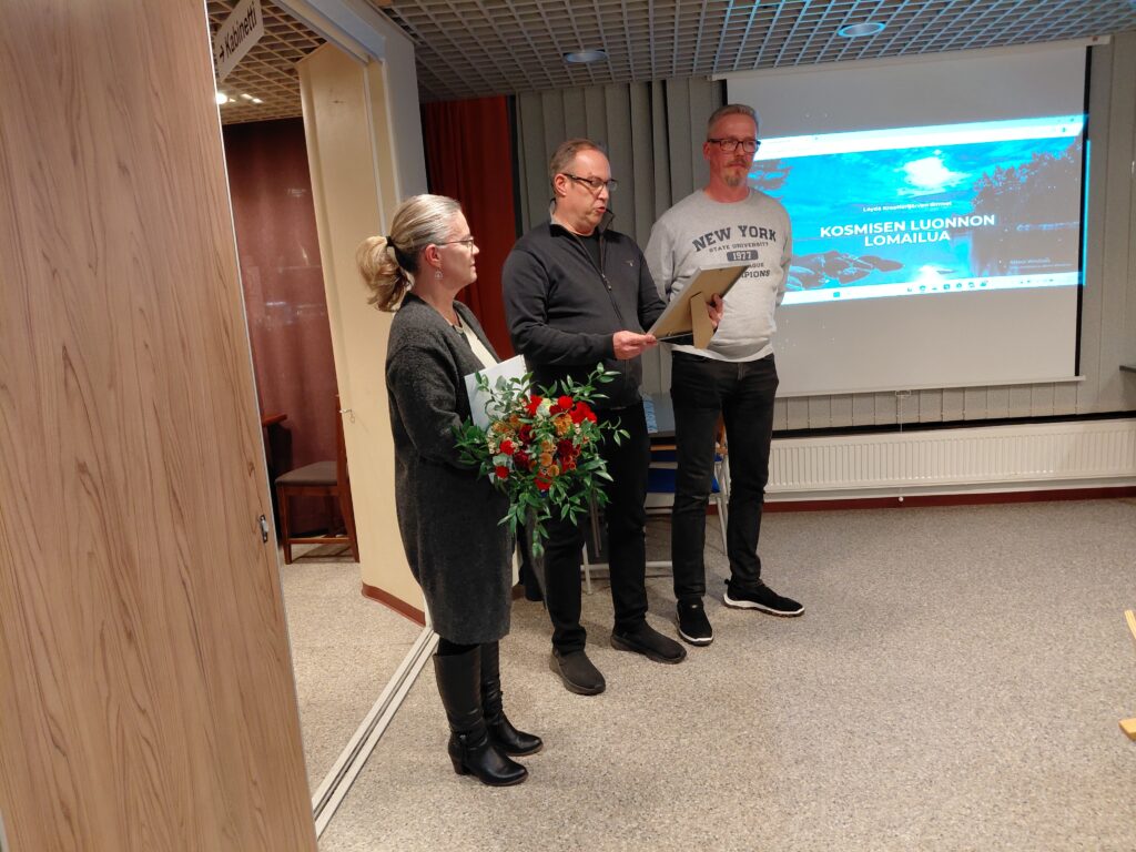 uoden 2025 toimija Daniel Pakulla (oik.). Palkitsemassa Sari Hyttinen (vas.) ja Jussi Keijonen.