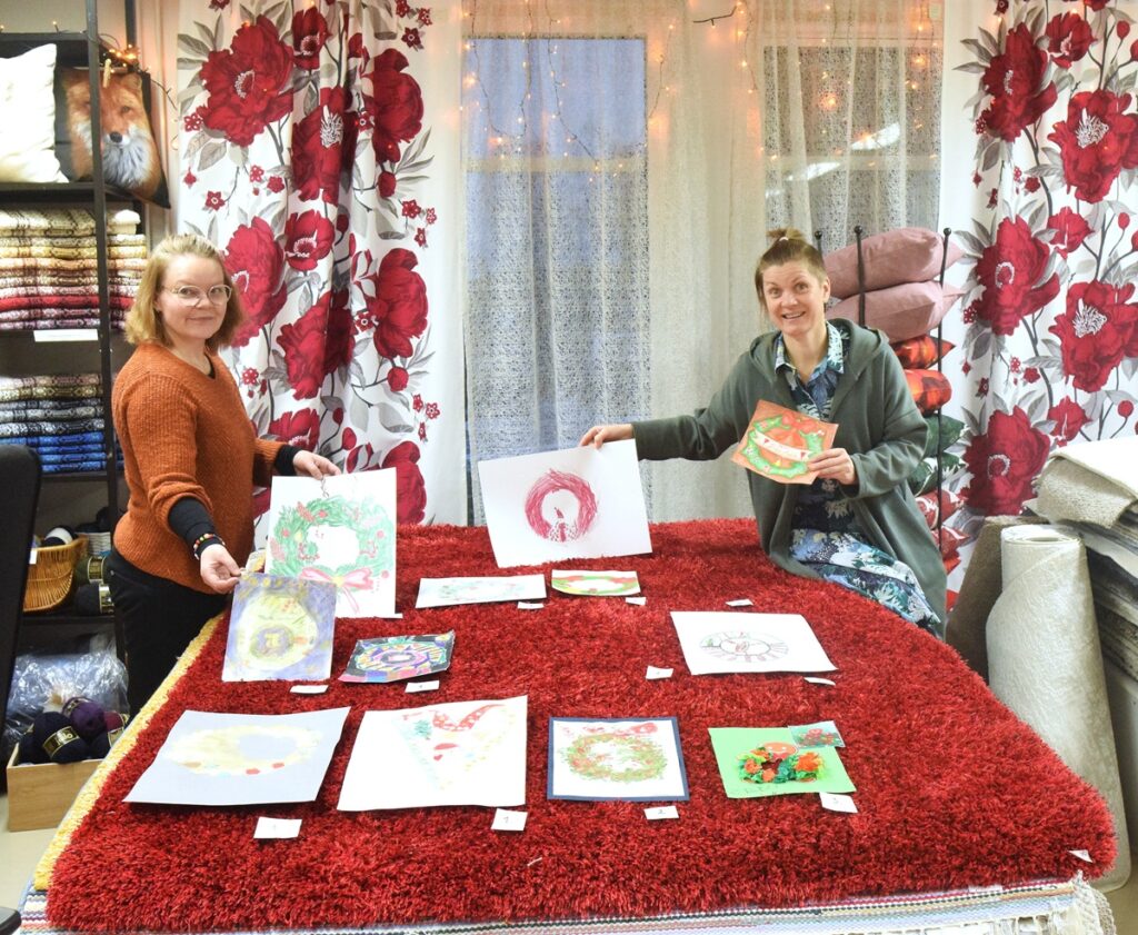 Taina Kangas (vas.) ja Maija Perälä valitsivat suosikkinsa upeista ja värikkäistä joulukransseista. Kaikki työt ovat jouluun saakka nähtävillä S-Market Lappajärven eteisessä.