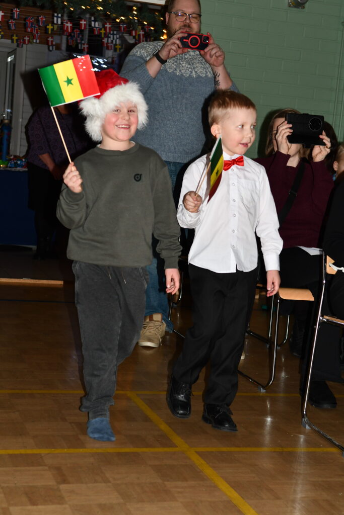 Esikoululaisten lippukulkue toi juhlaan useiden maiden lippuja.