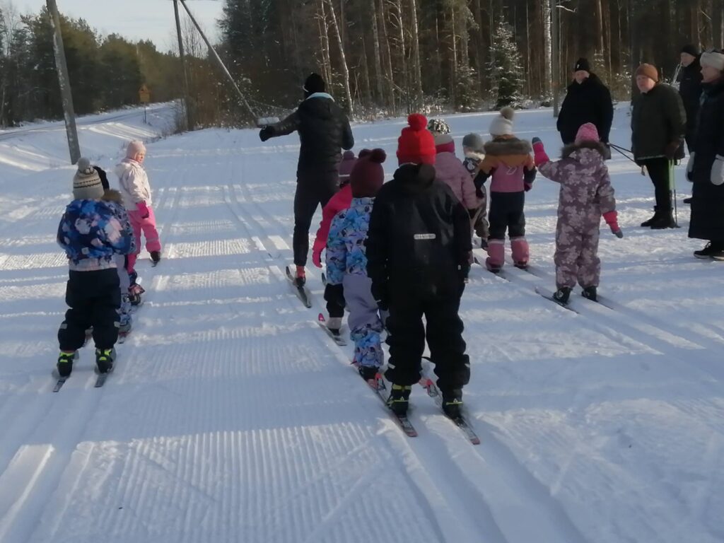 Jaloilla ponnistaen ja käsillä tehostaen edestä taakse, koululaiset seurasivat johtajaa ja huoltajat koululaisiaan.