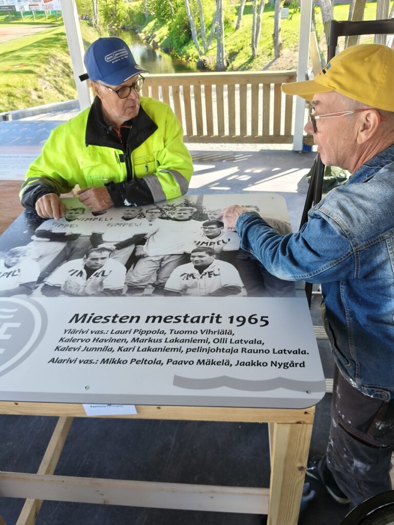 Mestareiden pöydässä Erkki Ahonen (vas.) ja Kuisma Rentola. Talkoolaiset ovat tärkeä linkki saattamassa Saarikenttää juhlakuntoon ja rakentamassa katsojille lisää viihtyvyyttä.