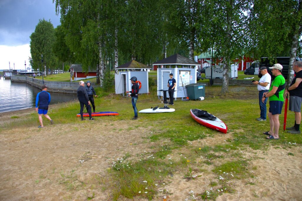 SUP-lautailijat valmistautuvat kisaan yleisön seuratessa.