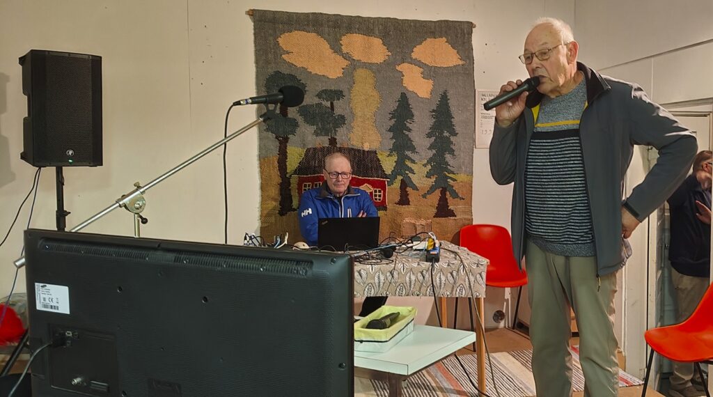 Karaokevuorossa lauluntaitaja Reijo Tamminen, tekniikasta vastasi pöydän takana istuva Pekka Metsälä.