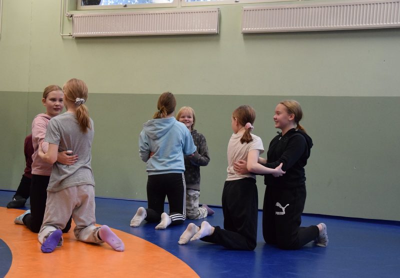 Lappajärven yhteiskoulun oppilaat pääsivät kokeilemaan painia Petra Ollin opastuksella. Kuvassa kuudennen luokan tytöt polvipainin parissa.